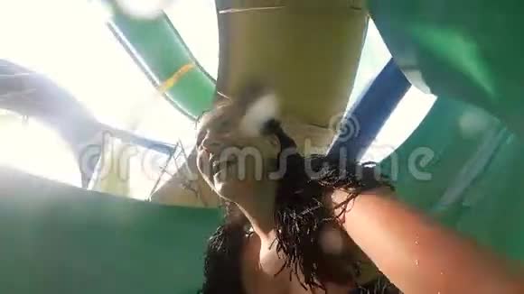感情幸福的女人在水上乐园滑滑梯视频的预览图