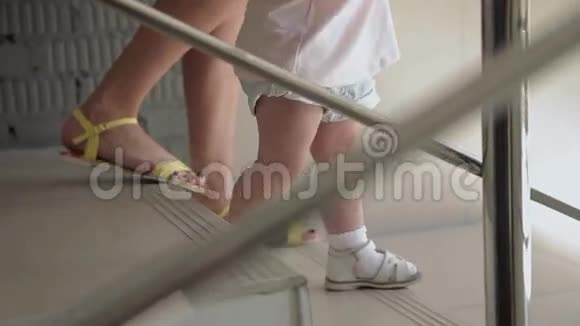 女孩和母亲一起走楼梯特写视频的预览图