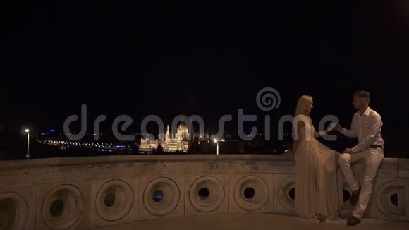 一对浪漫的情侣在华丽的布达佩斯激情地接吻夜色模糊视频的预览图
