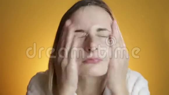 一个金发女人把脸溅在黄色背景上视频的预览图