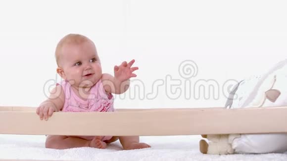 小女孩在婴儿床上挥手视频的预览图