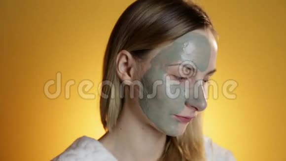 皮肤护理女人用刷子泥面罩涂在她的脸工作室拍摄视频的预览图