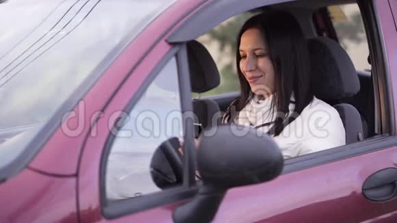 坐在车里用智能手机说话的女人视频的预览图