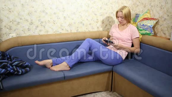 年轻女子坐在沙发上看书视频的预览图