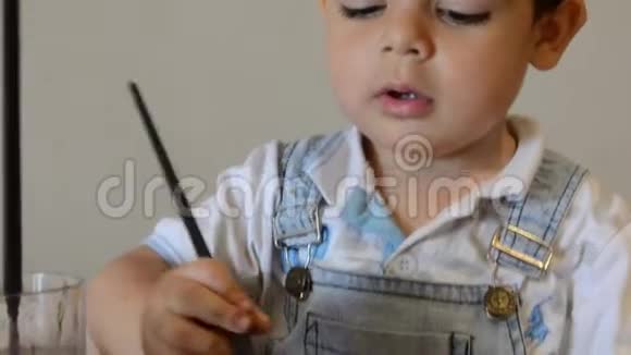 可爱的两岁男孩用水色作画视频的预览图