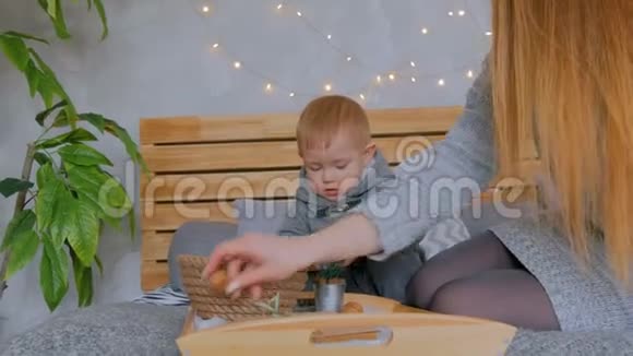 快乐的年轻母亲和她的小儿子玩核桃视频的预览图