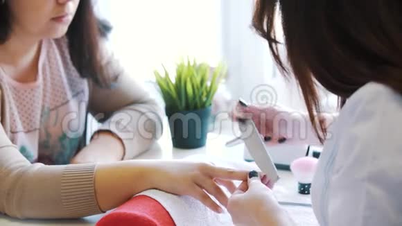 女人的手在美容院接受美甲打钉子特写选择性聚焦视频的预览图