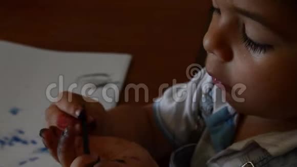 可爱的两岁男孩用水色作画视频的预览图