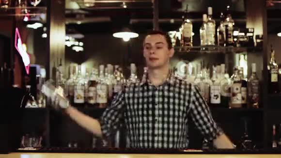 酒保拿着两只眼镜站在酒吧后面做着惊人的把戏视频的预览图
