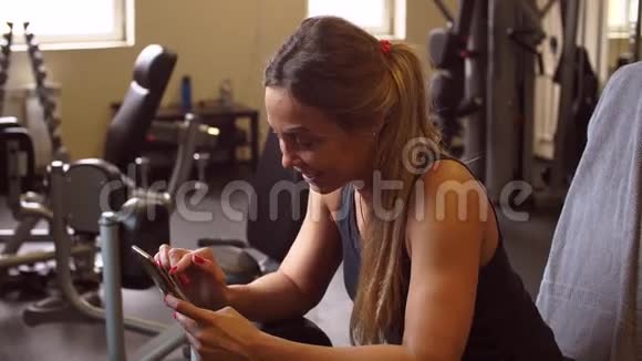 漂亮的运动女孩在经过艰苦训练后在健身房聊天特写视频的预览图