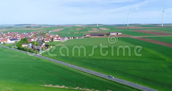 在现代欧洲的一个小村庄附近飞行在风力发电机附近飞行在风力发电机的背景下飞行视频的预览图