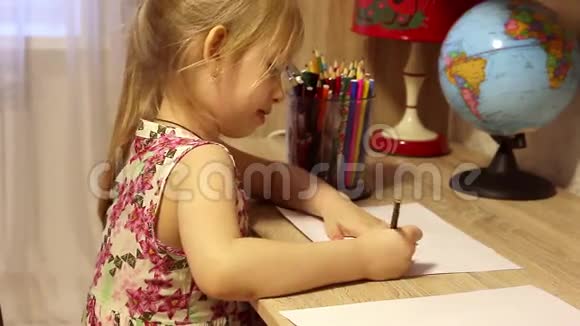漂亮的小女孩在他的房间里用铅笔在纸上画画视频的预览图