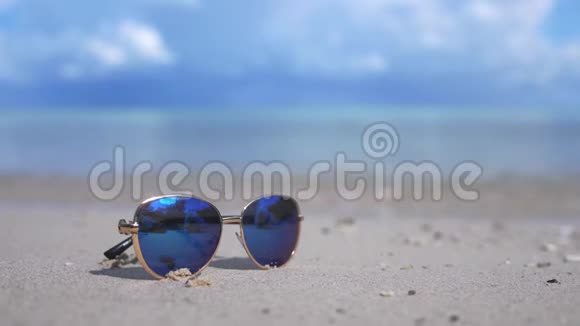 旅游度假理念白色海滩上的蓝色太阳镜蓝绿色海的背景与副本视频的预览图