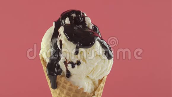冰淇淋和巧克力酱在华夫饼锥粉红色背景视频的预览图