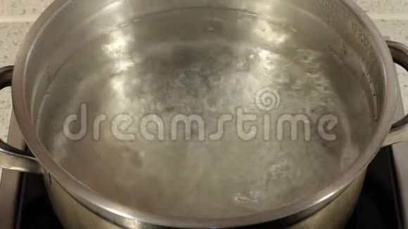 在平底锅里煮水在炉子上的平底锅中气泡中的水泡视频的预览图