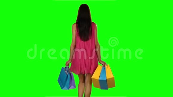 布鲁内特女士买衣服购物袋绿色屏幕慢动作视频的预览图