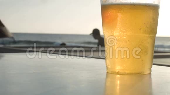 一杯啤酒人们沿着海滩散步视频的预览图