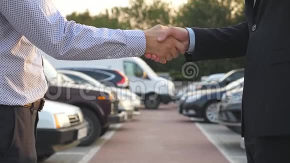 穿西装的男性把车钥匙给他的朋友商人的手臂通过汽车钥匙两个企业之间的握手视频的预览图