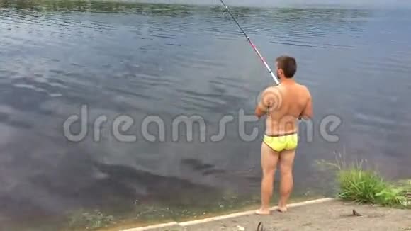 穿短裤的人在湖岸钓鱼视频的预览图