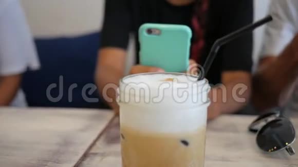 女人在咖啡店用手机冰咖啡饮料特写高清慢动作生活方式镜头视频的预览图