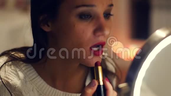 年轻女孩在涂红唇膏之前视频的预览图