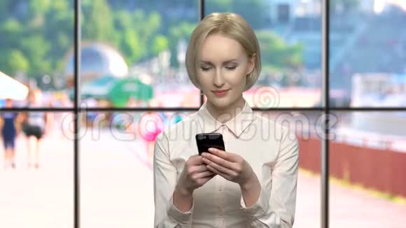 漂亮的微笑办公室女人用手机视频的预览图