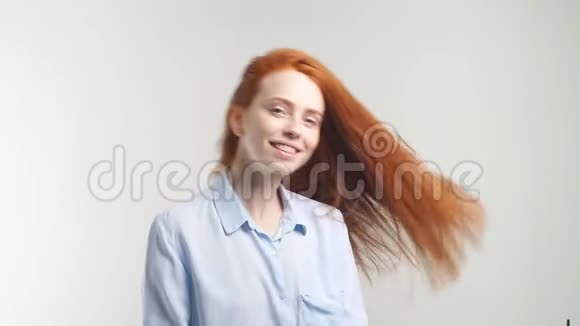美丽开朗的红头发女孩的肖像她的卷发笑着笑着看着白色的摄像机视频的预览图