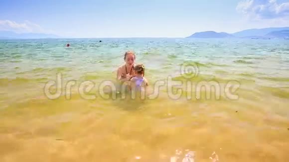 小女孩跟着妈妈的舞会来到沙滩视频的预览图