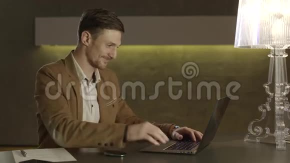 商人对着笔记本电脑的屏幕微笑视频的预览图