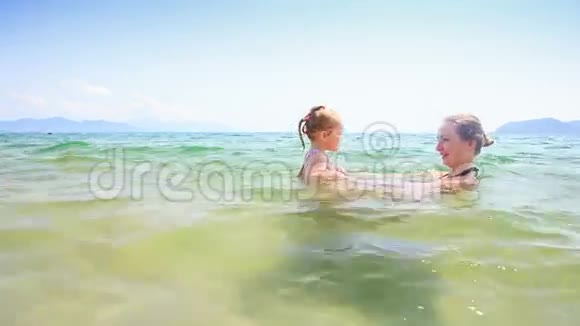 母亲丹德斯小女儿在蔚蓝的大海中嬉戏视频的预览图