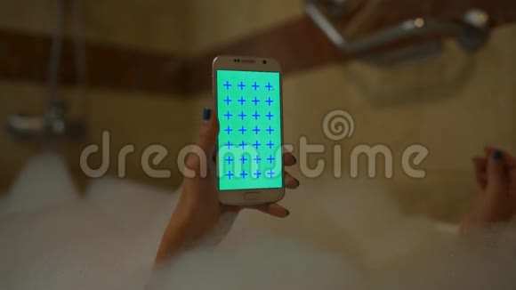 女孩用手机洗澡垂直视频的预览图