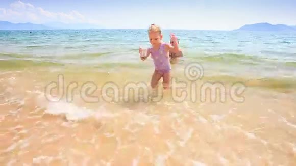 小女孩在海滩上的沙堡上漂流视频的预览图