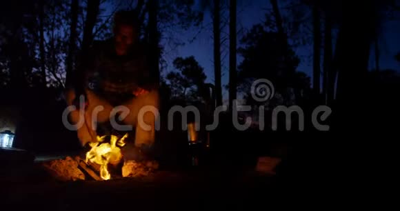 坐在森林篝火旁的人视频的预览图