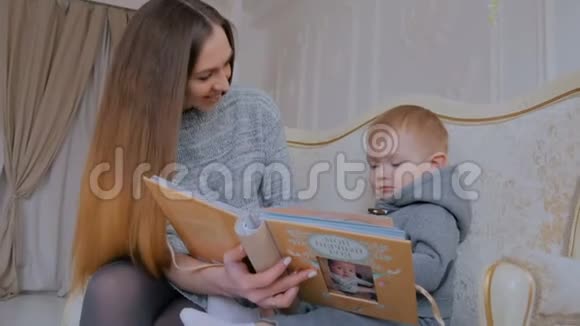 年轻的母亲和她的小儿子正在看照片视频的预览图