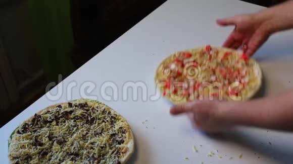 准备披萨这个人用螃蟹棒和桌子上的蘑菇调整比萨饼视频的预览图