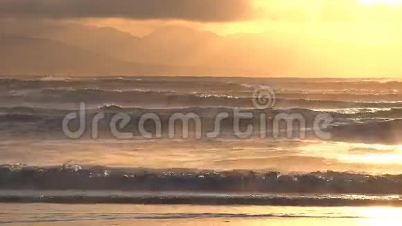 缥缈的朝霞笼罩着哗哗的海浪视频的预览图