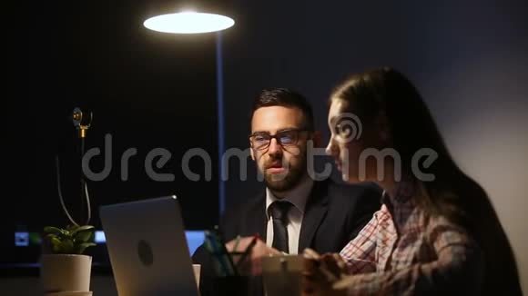 商人和女商人在办公室工作到深夜用电脑视频的预览图