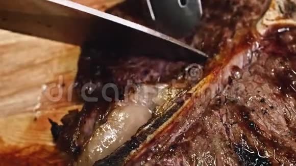 烤牛肉肉排芦笋红辣椒和餐具放在木制餐盘上视频的预览图
