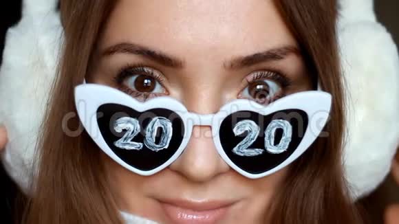 一位戴太阳镜的女士的特写肖像编号2020新年圣诞节女孩微笑着看着镜头视频的预览图