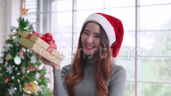 年轻的亚洲女孩捧着圣诞礼物面带笑容视频的预览图