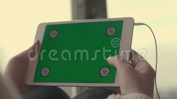 女性手在平板电脑上使用绿色屏幕和滚动页视频的预览图