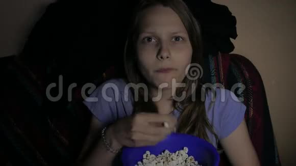 女孩在电影院看电影贪婪地吃着爆米花4UHDK视频的预览图