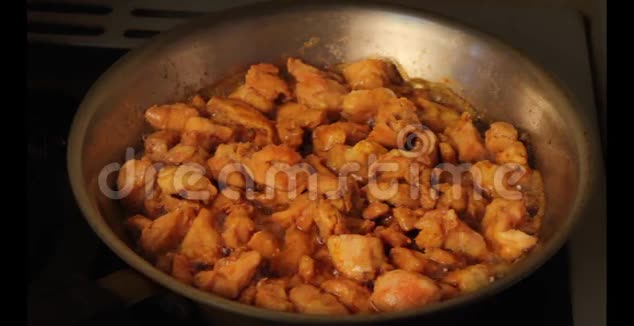 在平底锅中用油煎煮的辛辣咖喱鸡肉视频的预览图