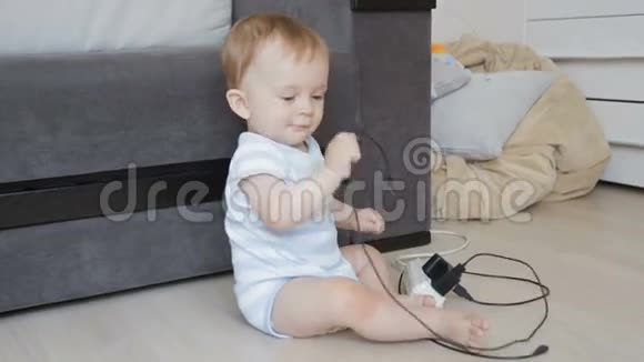 婴儿独自坐在房间里玩插座和电线视频的预览图