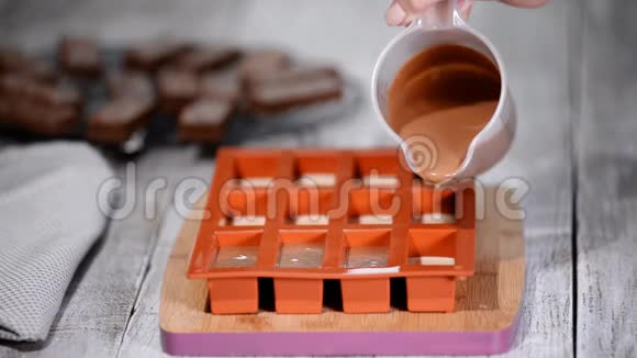 糕点厨师用巧克力慕斯填充硅胶模具做法式甜点视频的预览图