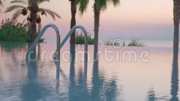 度假酒店的室外游泳池日落时可观看视频的预览图