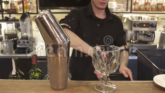 男手调酒师把冰块倒入鸡尾酒中视频的预览图