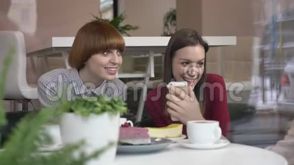 三个年轻的白种人女孩坐在咖啡馆里笑着笑着朋友陪伴闲聊对话讨论视频的预览图