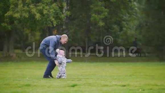 幸福的家庭爸爸妈妈和小女孩走在秋天的公园里爸爸去女儿家视频的预览图