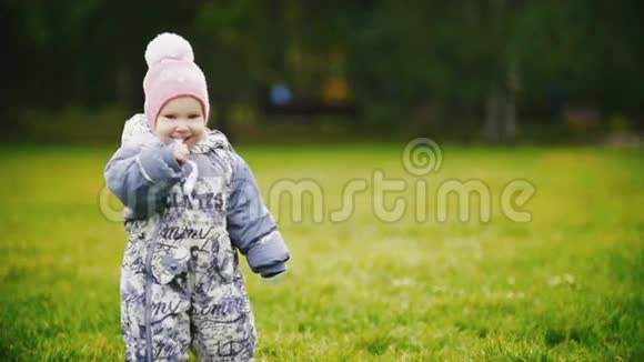 幸福的家庭在秋天公园散步的母子小女孩一个婴儿在嚼一张纸慢动作视频的预览图